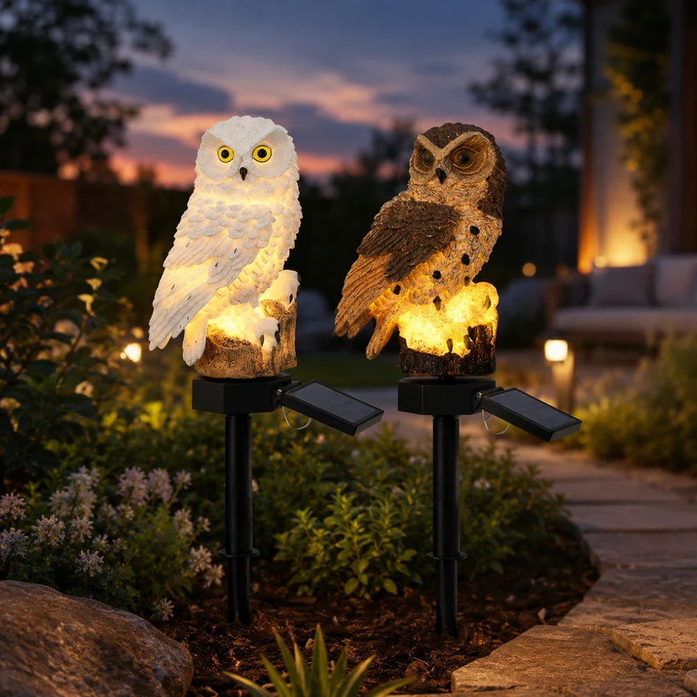 Solar owl pathway light glowing in a garden