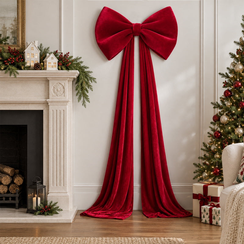 Long burgundy velvet bow hanging on a wall beside the Christmas fireplace